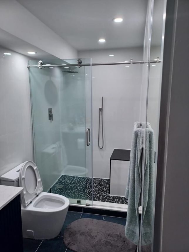 Queens Bathroom Remodeling: a small bathroom was remodeled to fit a toilet and shower. The bathroom contractors added fixtures, new tiles, and a glass to enclose the shower.