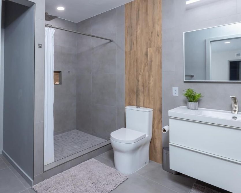 Remodeling Bathroom: this bathroom was remodeled to look modern with gray tiles and wood accent.